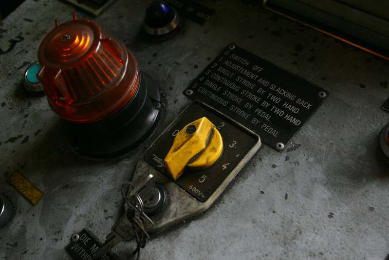 Close-up of a physical toggle switch labeled 'MONITORING ENGAGED' next to a terminal window showing live status logs and uptime metrics